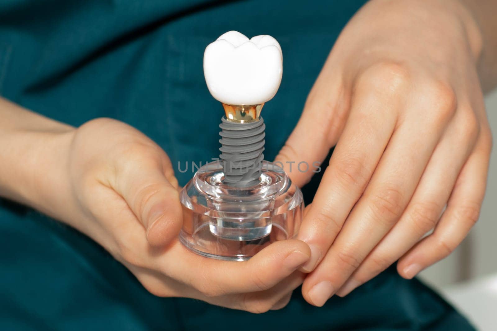 Dentist prosthetist holding a dental implant in his hands