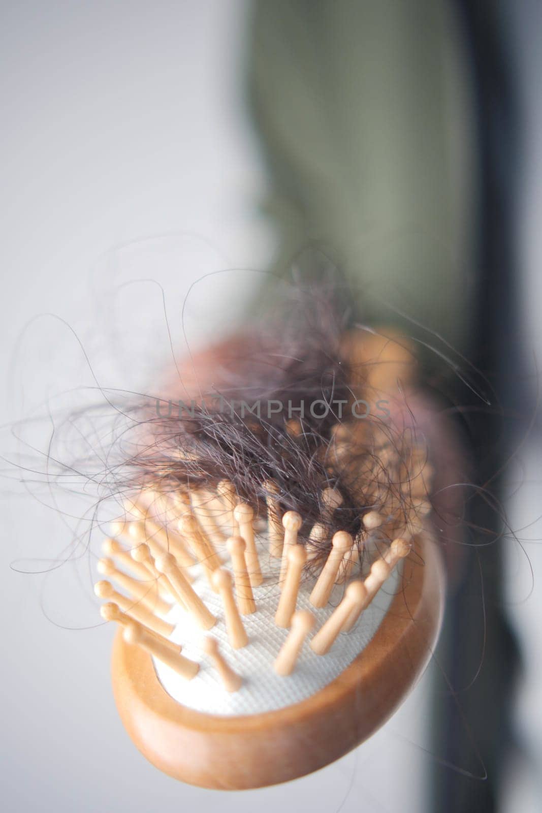 A close-up view of a hairbrush with embedded hair strands.