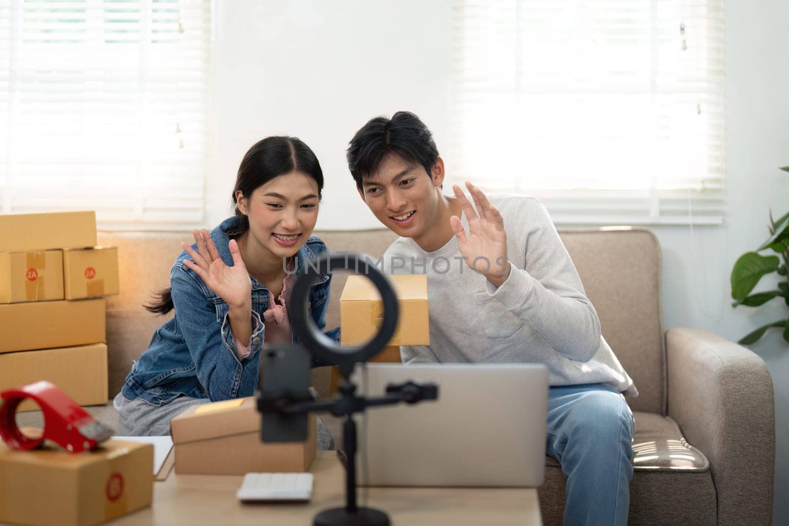 In a lively online session, the couple enthusiastically interacts with their audience, embodying the energy of modern entrepreneurship through digital communication tools.