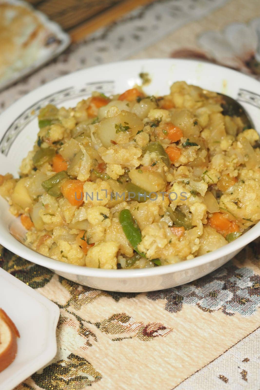 A colorful mix of vegetables and grains is served in a bowl ready to eat.