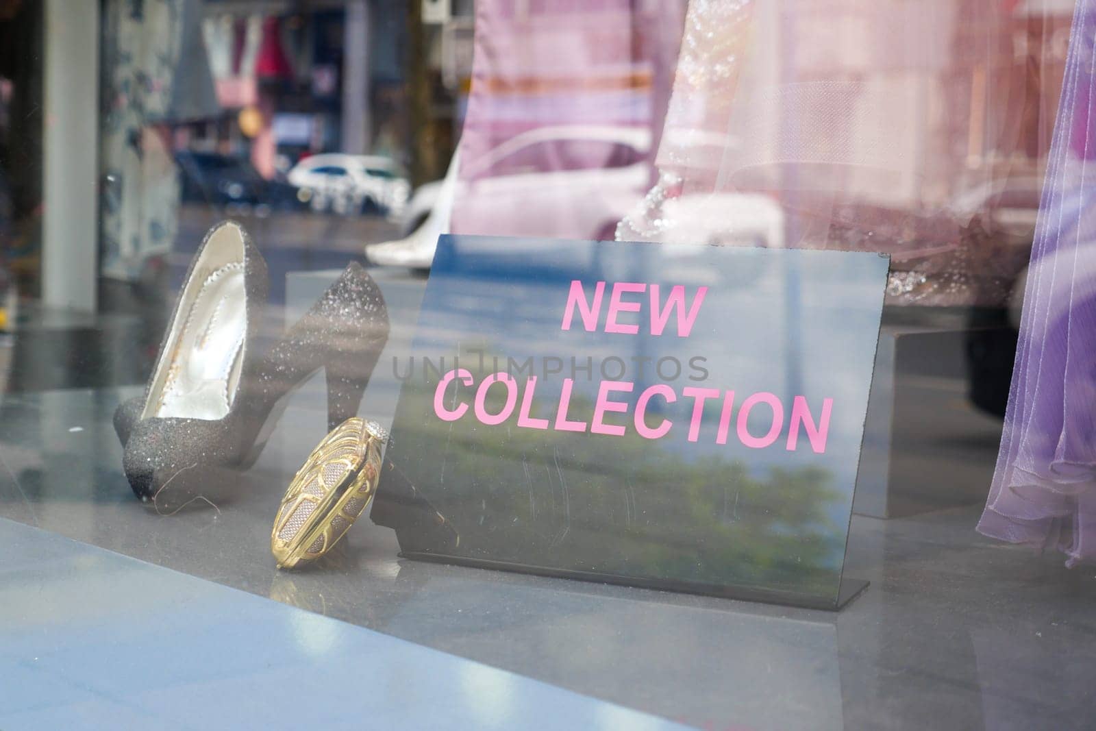 A storefront displays a sign about a new collection of footwear.