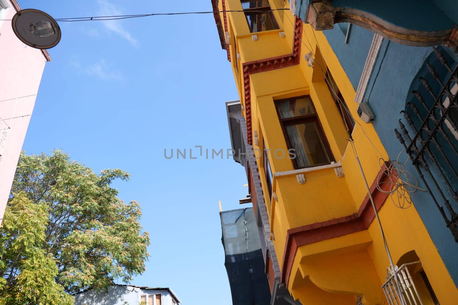 Bright yellow building stands out under a sunny sky with sparse clouds.