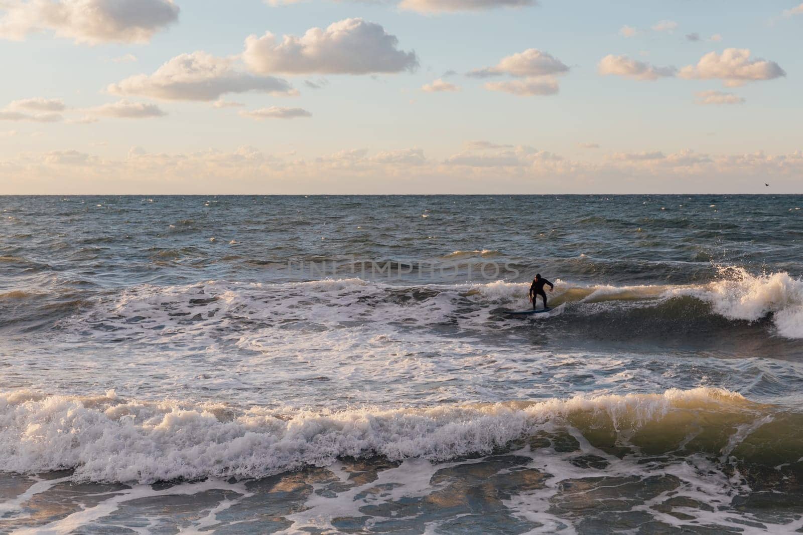 surfers on boards riding the waves in a storm