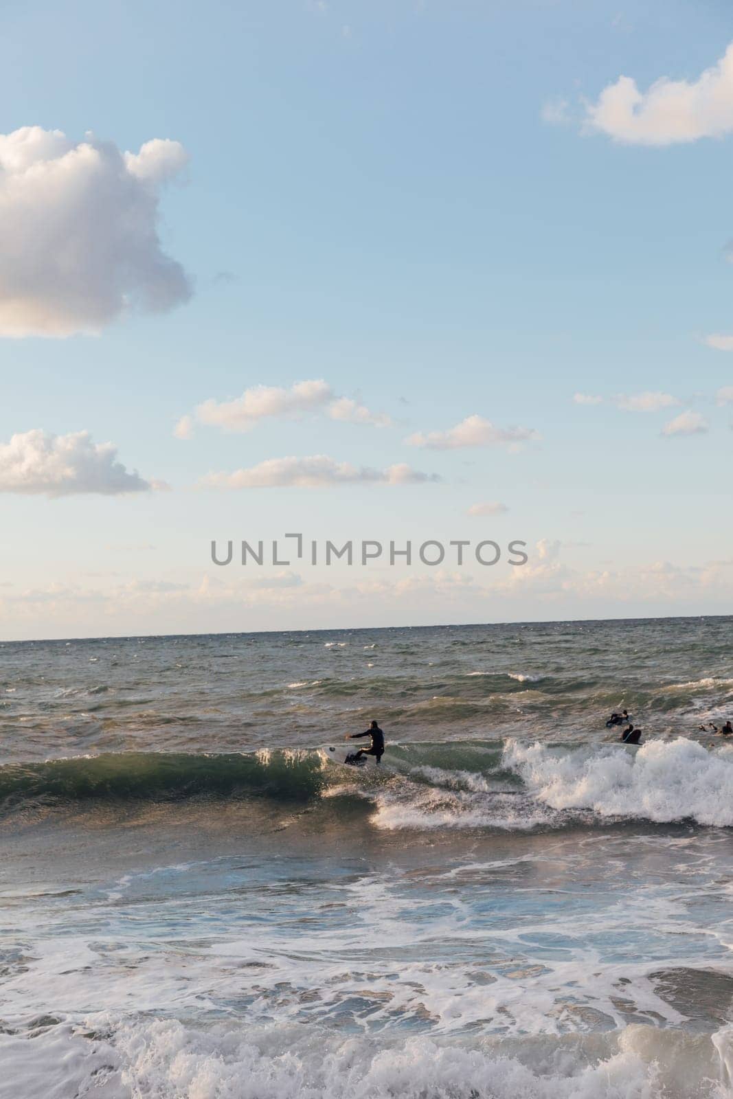 surfers on boards riding the waves in a storm