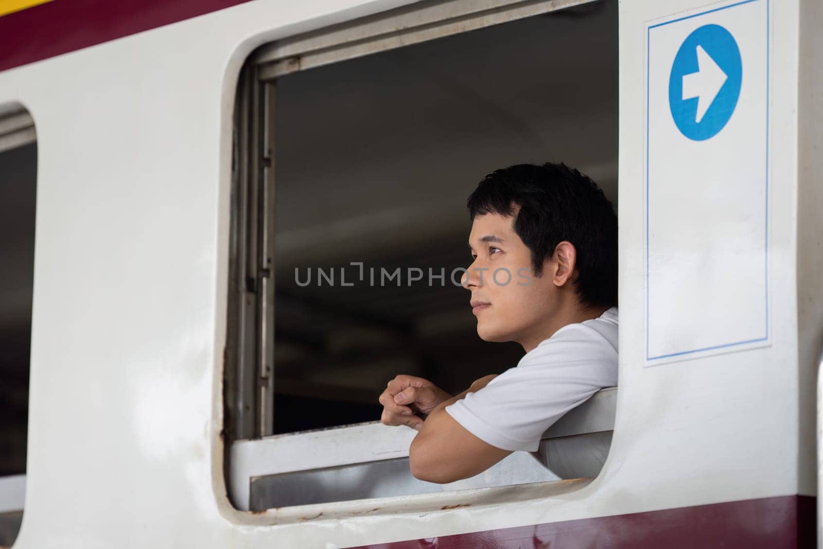A traveler lost in contemplation while looking out of a train window, representing the introspective moments of a journey and the excitement of adventure ahead.