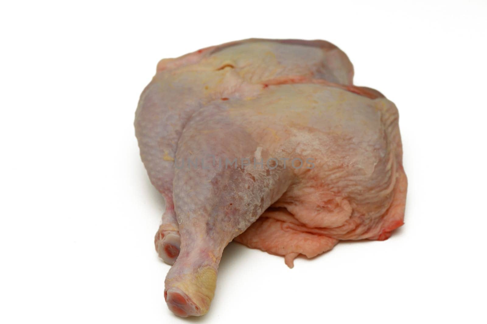 Two raw chicken legs are displayed on a clean surface, revealing their skin texture and color. Ideal for a variety of culinary dishes, they await seasoning and cooking.