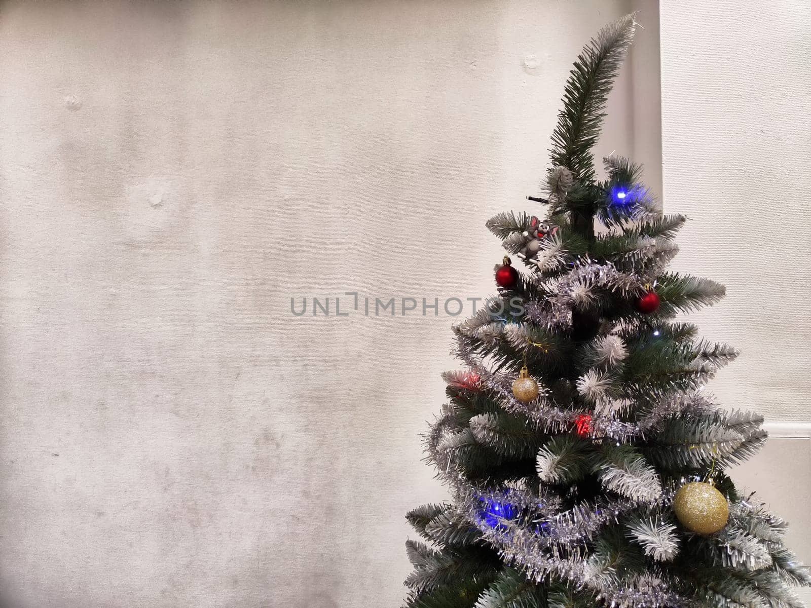 A Christmas tree adorned with shimmering decorations stands in a warm indoor space, radiating festive cheer and inviting joy.