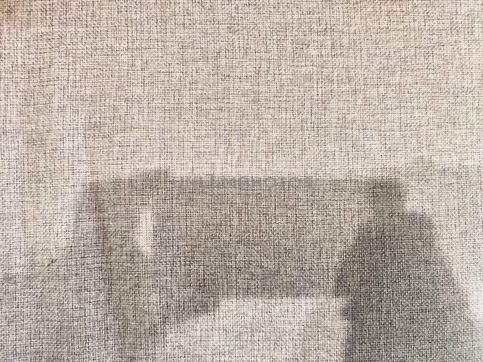 Soft fabric texture envelopes a space where shadows of objects hint at creativity and inspire reflection in minimalistic design.