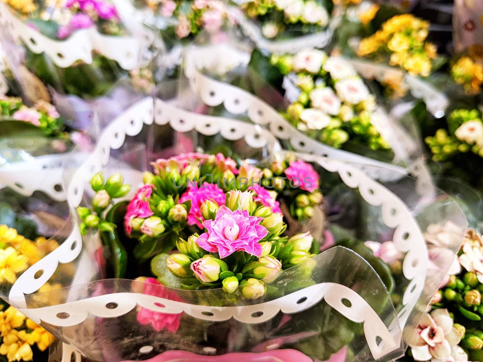 Colorful bouquets of flowers are creatively arranged and displayed at a lively market, highlighting the beauty of spring blooms.