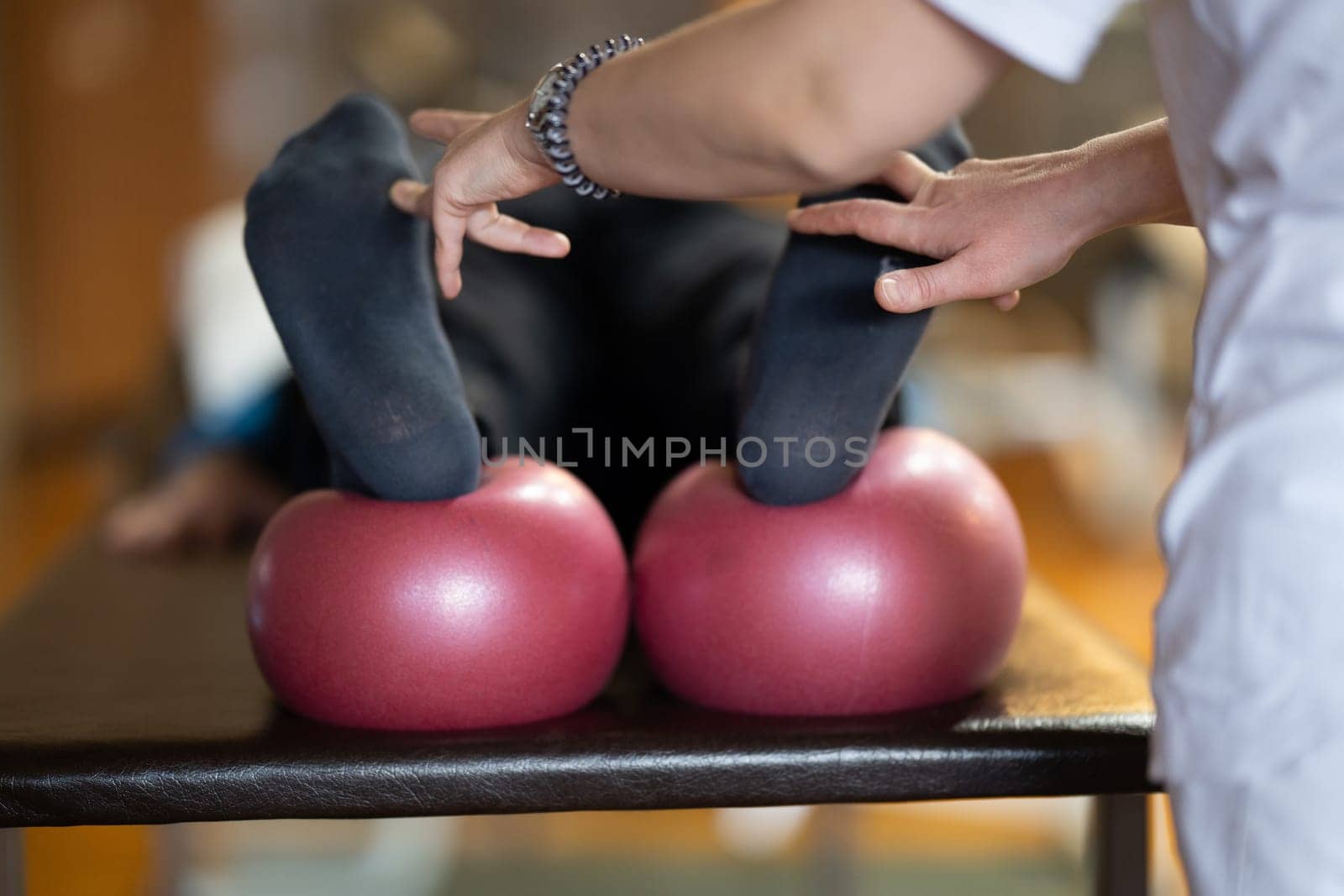 A physiotherapist treating a patients foot in a busy rehabilitation center, focusing on recovery and mobility improvement.