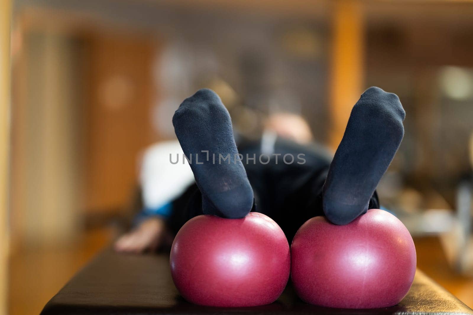 A close up shot of a patients legs resting on rehabilitation balls, aiding in recovery and improving flexibility during therapy