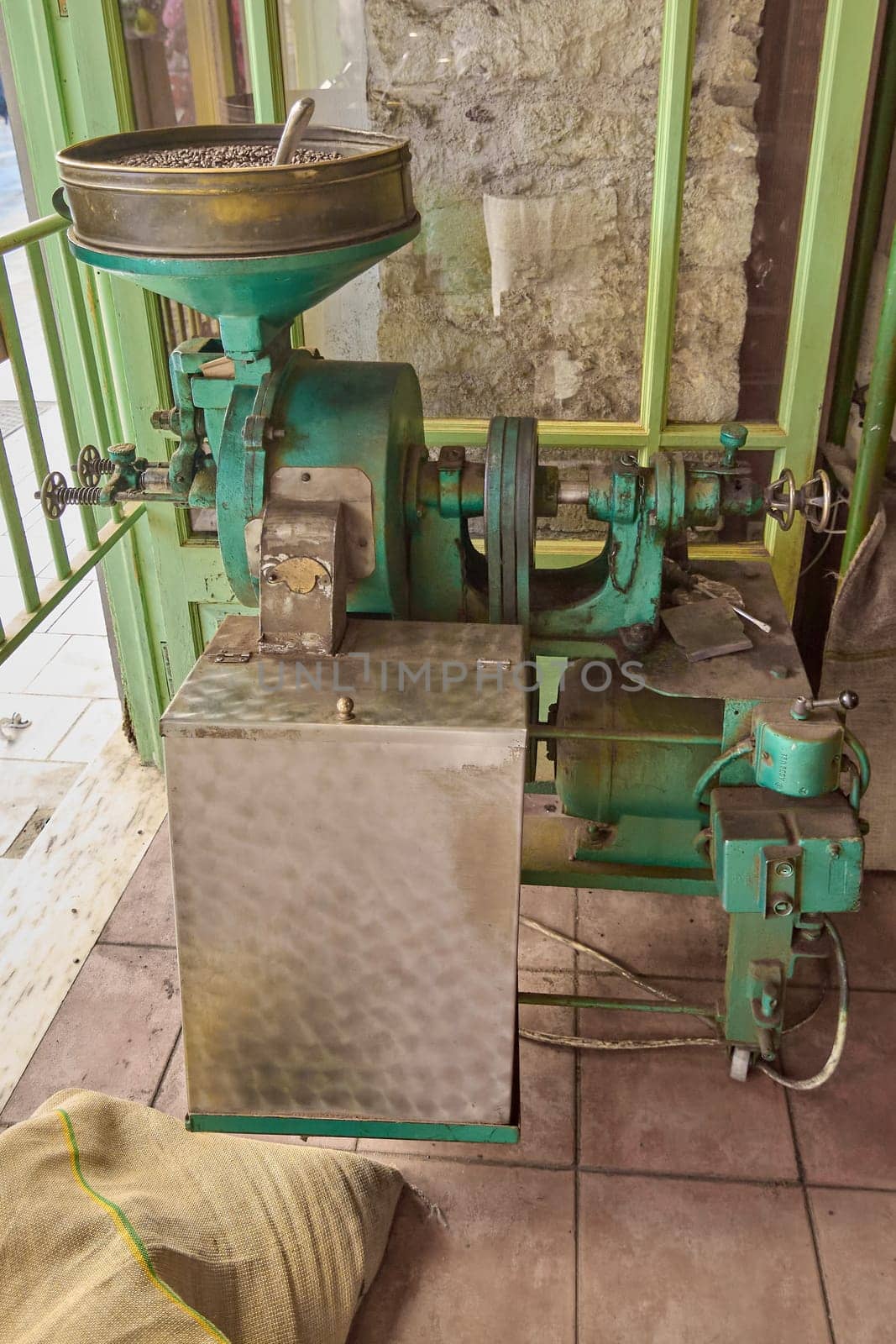 Crete.Greece - april 02, 2025: Industrial coffee roasting machine processing beans, emphasizing metallic structure and precision controls for artisanal coffee production.