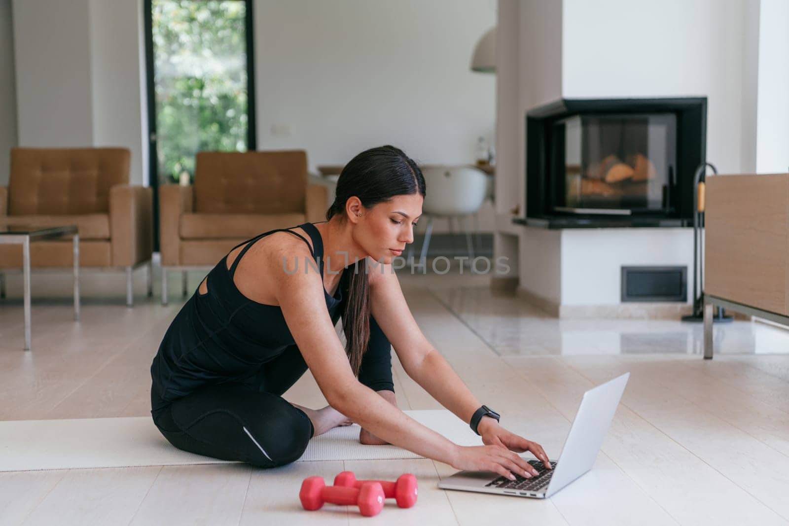 Young Beautiful Female Exercising, Stretching and Practising Yoga with Trainer via Video Call Conference in Bright Sunny House. Healthy Lifestyle, Wellbeing and Mindfulness Concept