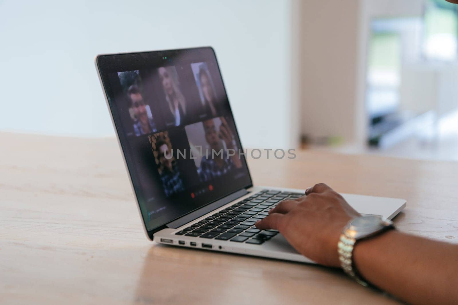 Photo of a laptop with modern headphones on a wooden table in a house with a modern interior