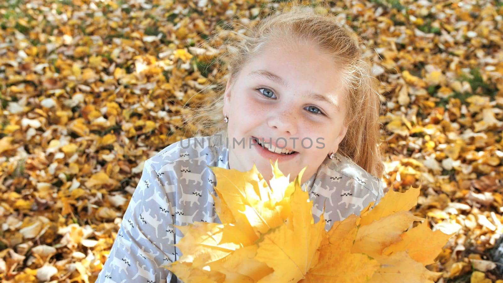 Smiling teen girl posing with autumn leaves
