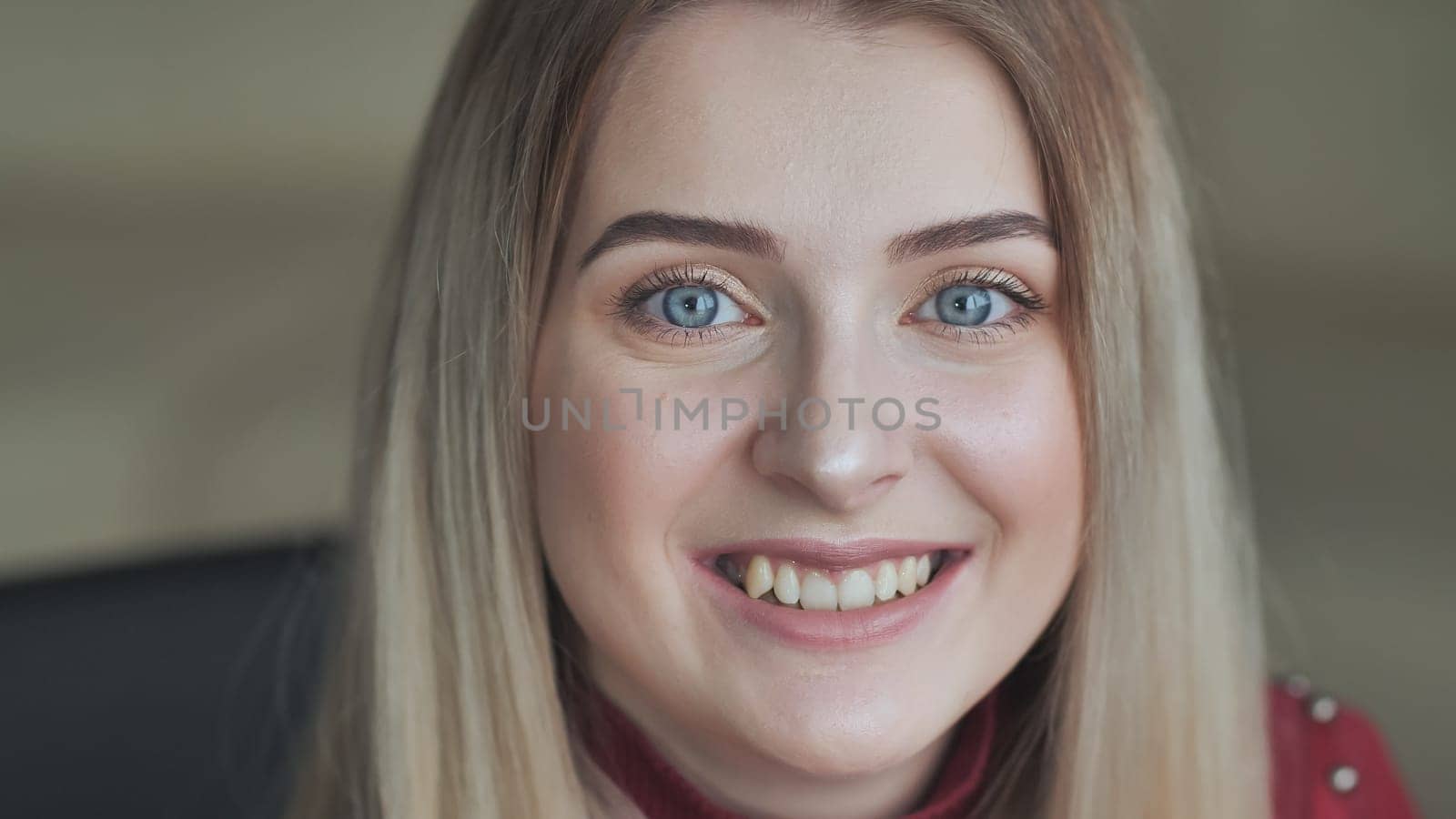 The blonde girl shows off her light makeup while smiling