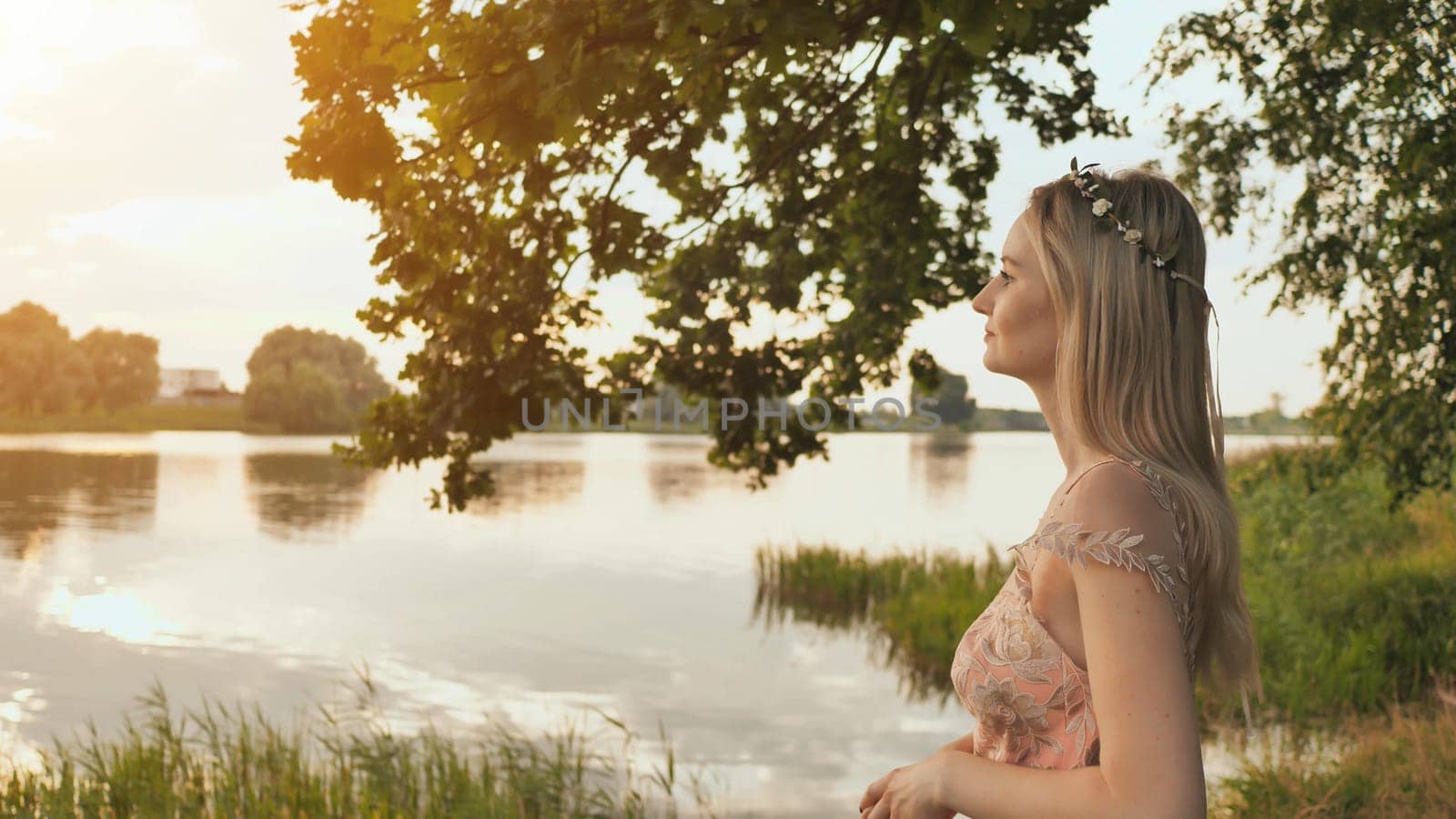Beautiful young blond woman outdoors portrait near the lake