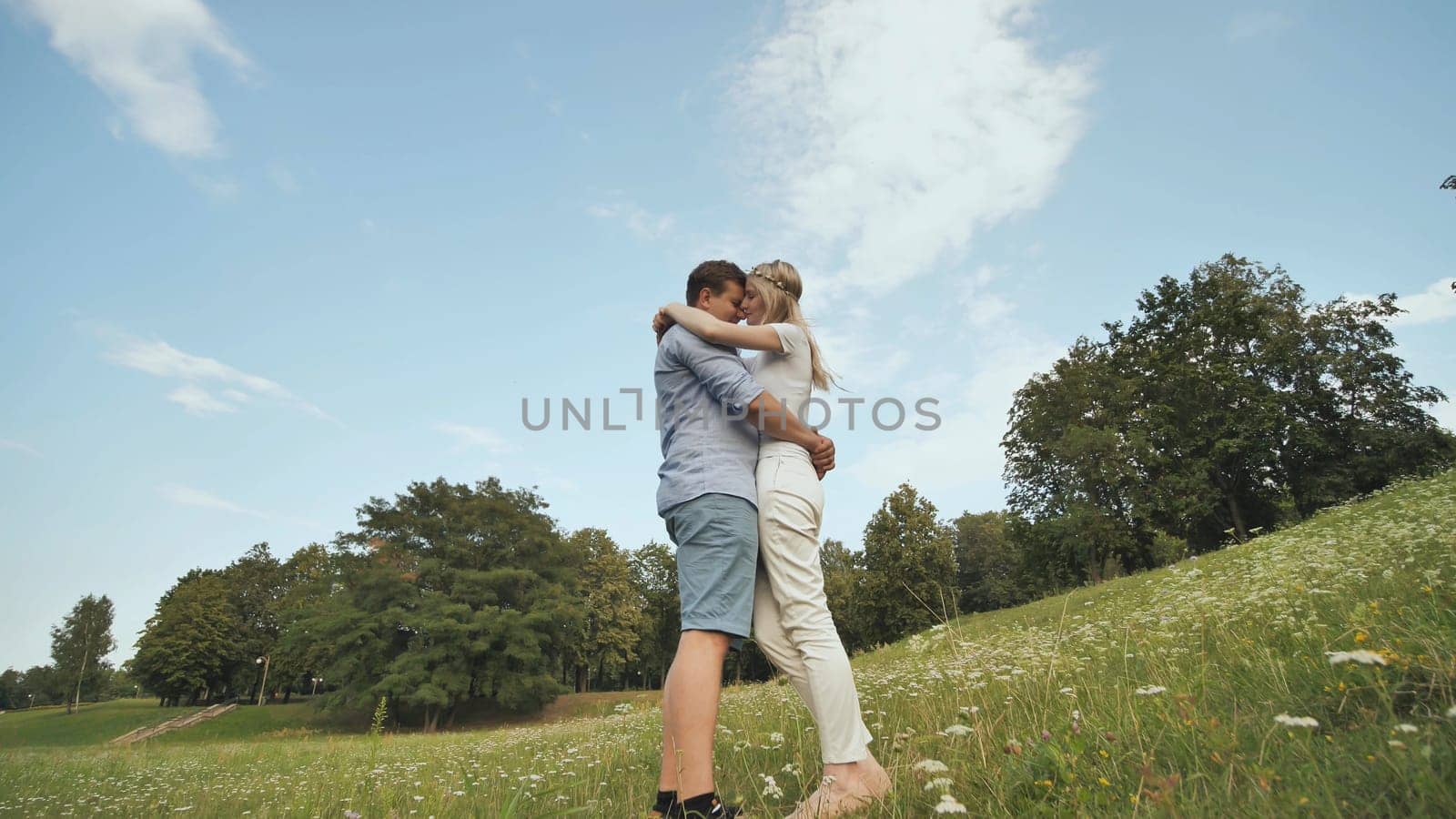 A young man and woman are standing in parks hugging each other.Video in motion and rotation