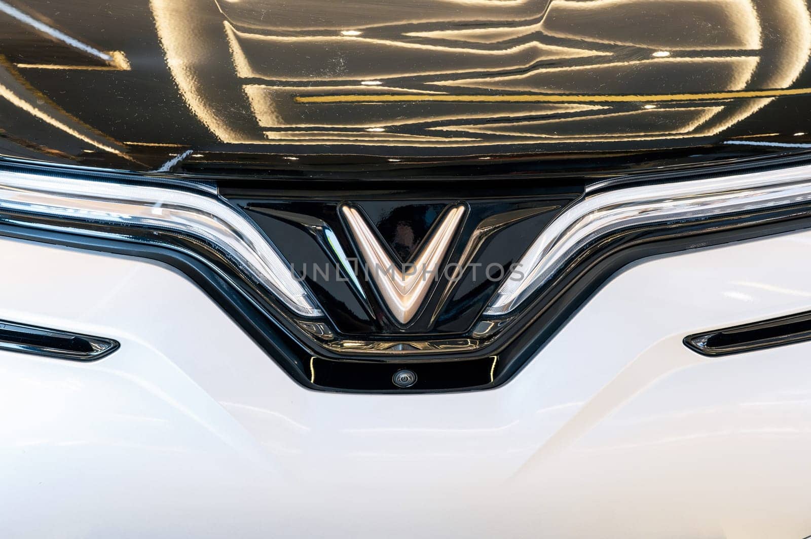 Vinfast logo on the hood of modern Vietnamese Vinfast VF8 electric car at automobile exhibition close-up. Nha Trang, Vietnam - April 01, 2025