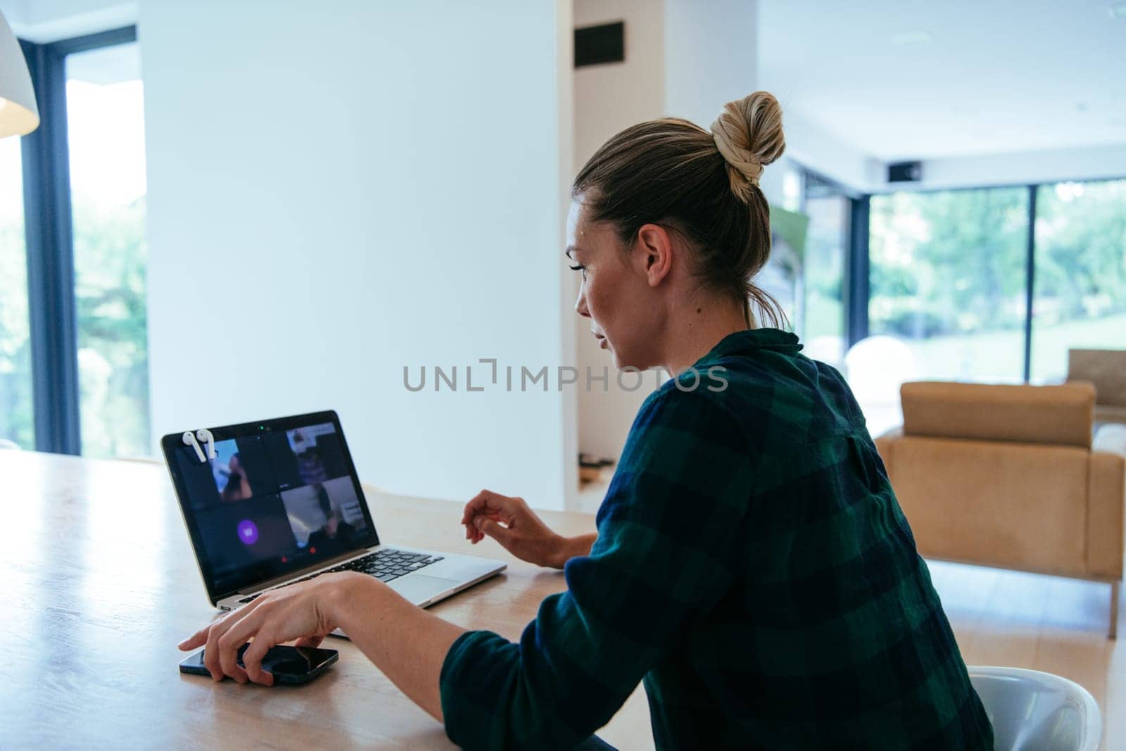 A woman sitting in the living room using a laptop is looking at cam talk by video call with business friends and relatives. The headshot is Job interview answering questions.