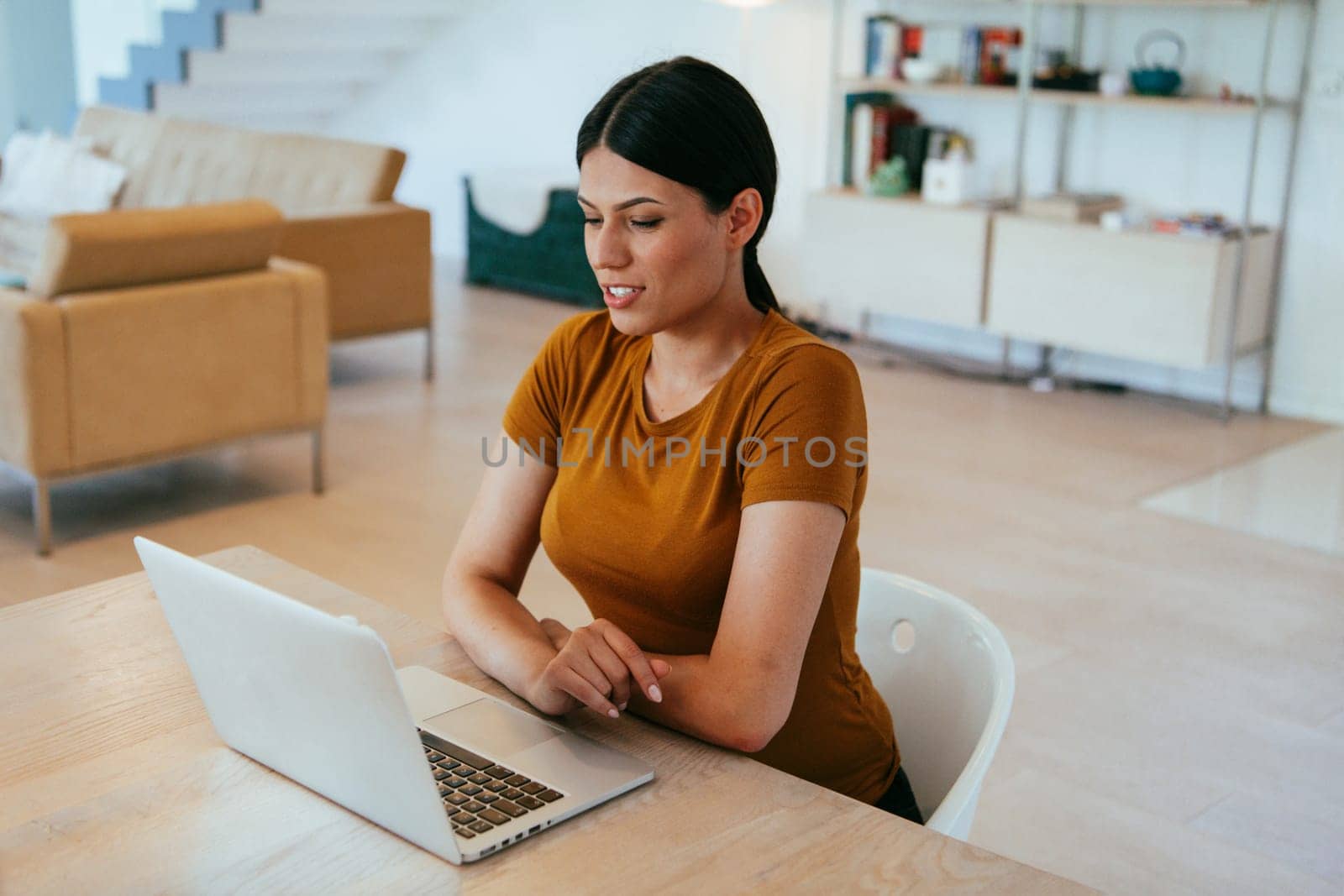 Woman sitting in living room using laptop looking at cam talk by video call with business friend relatives, head shot. Job interview answering questions