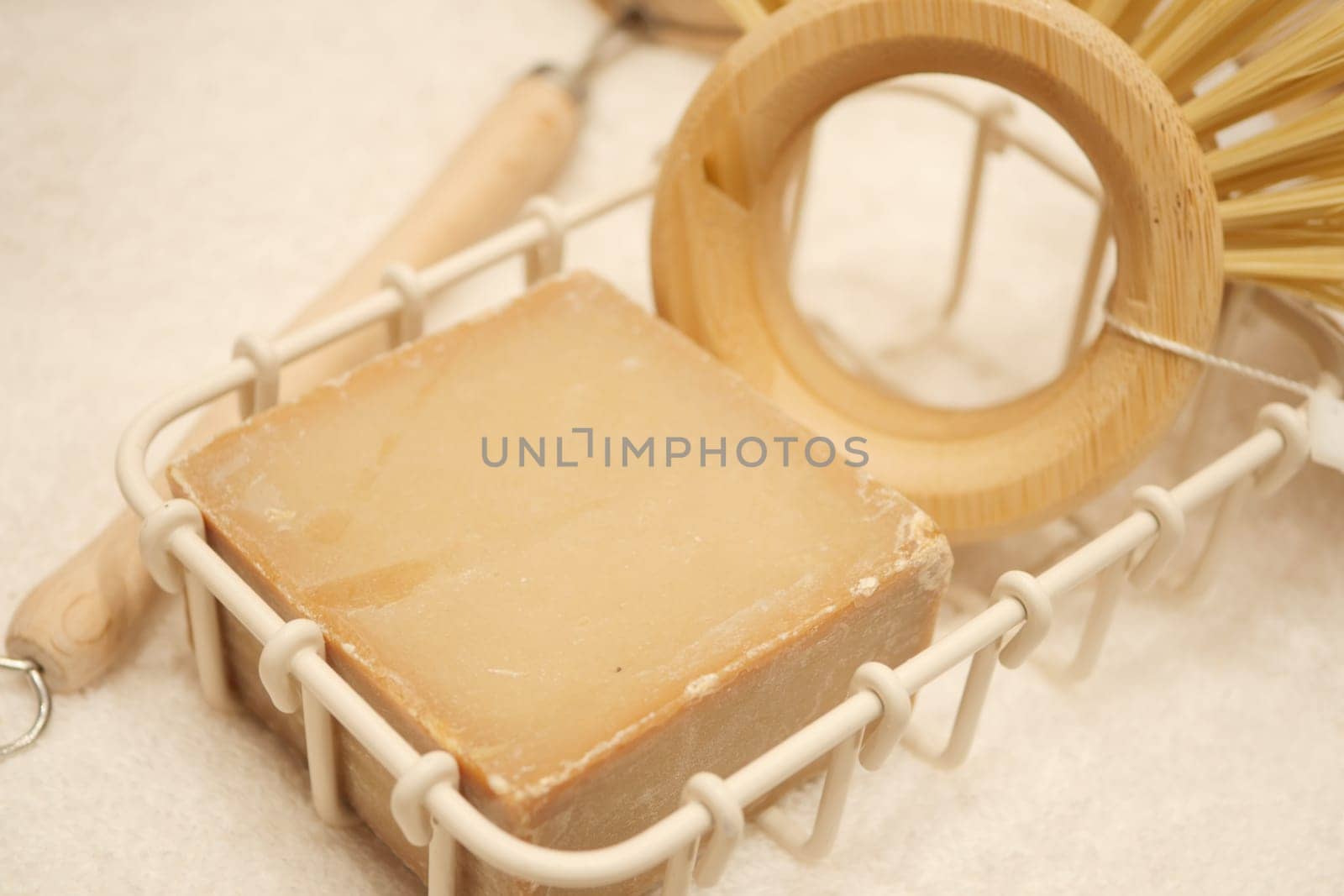 Handcrafted soap accompanied by bamboo tools on a textured surface.