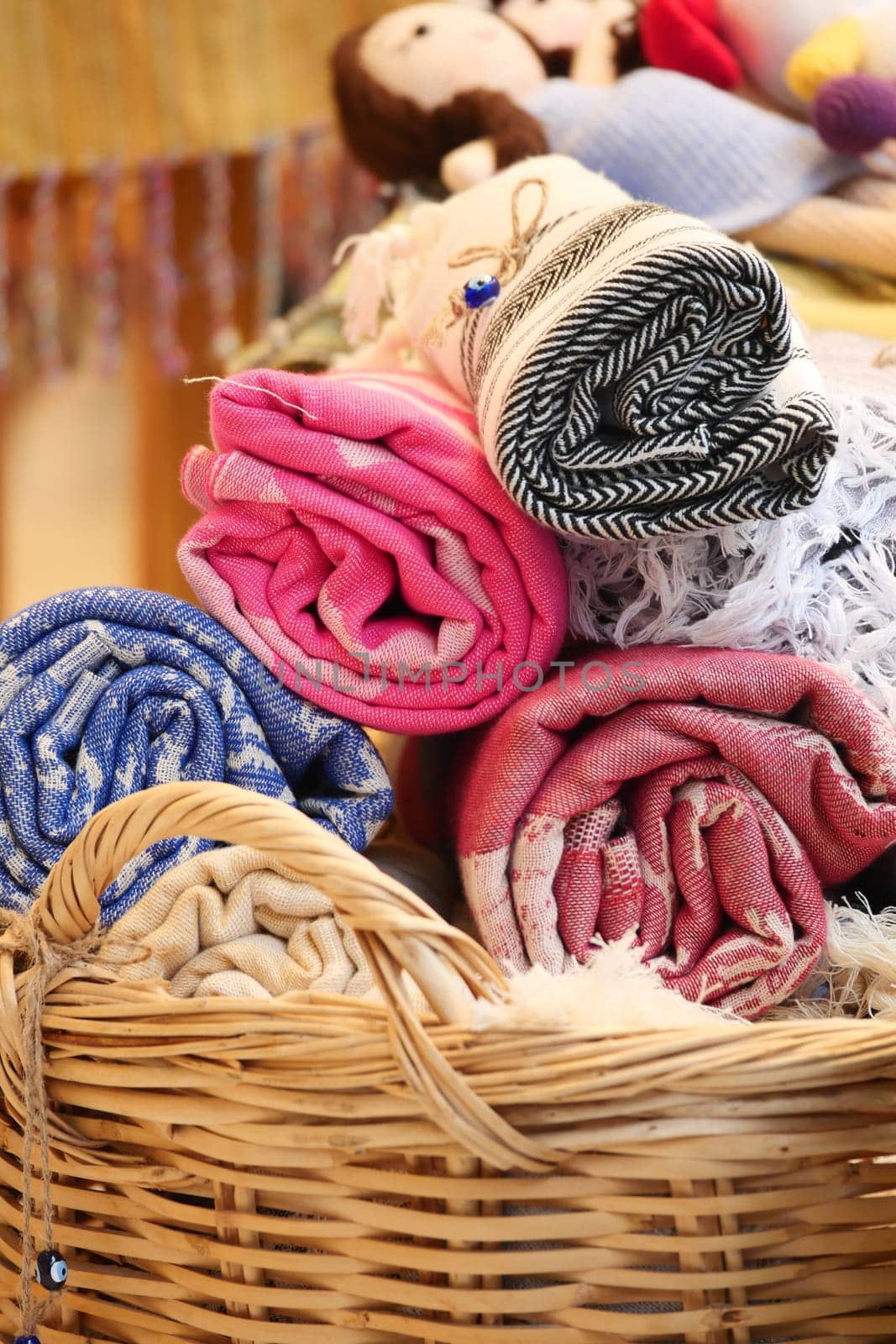Brightly colored rolled textiles and handcrafted dolls display craftsmanship.