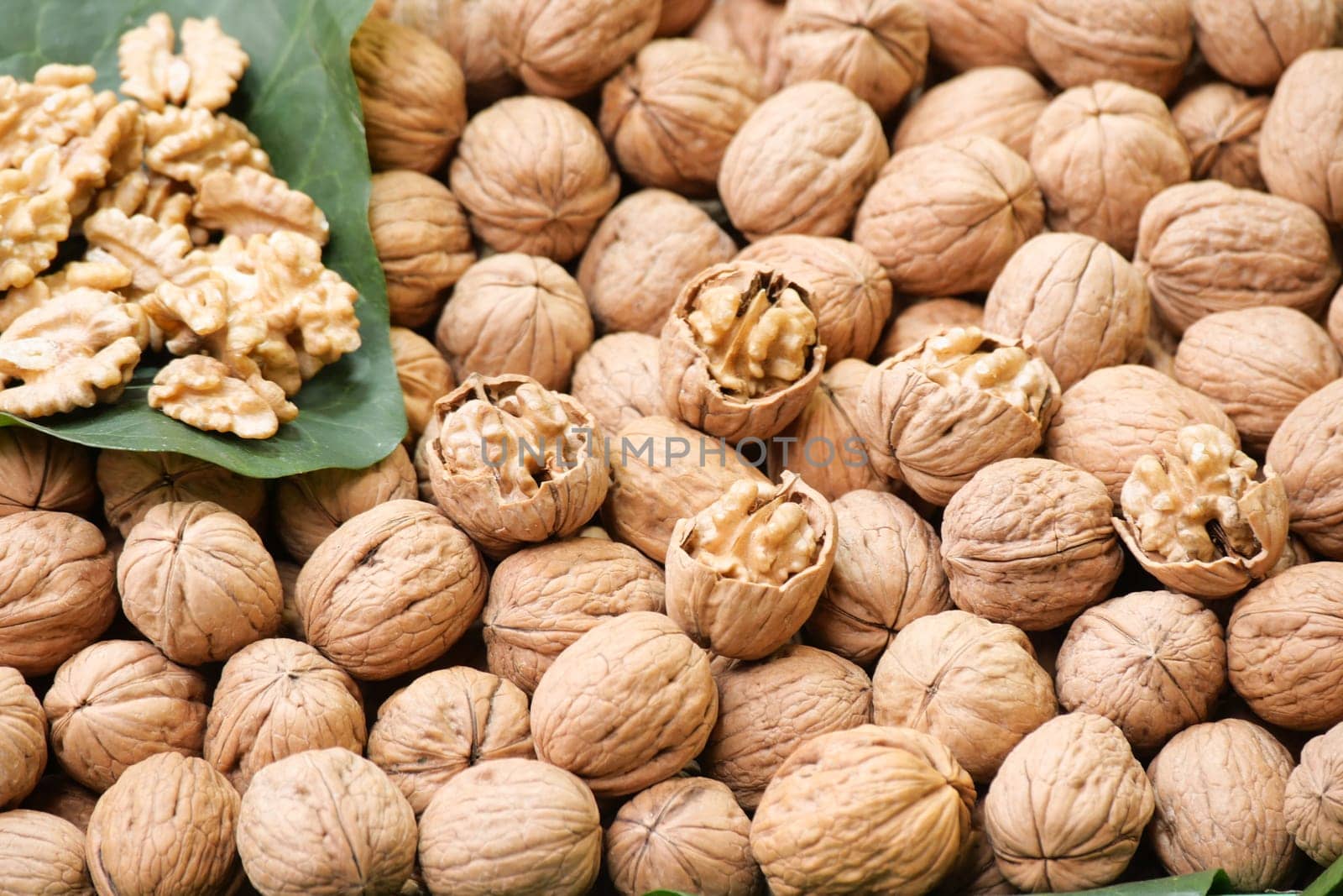 Walnuts are arranged with their shells, creating a rustic market display.