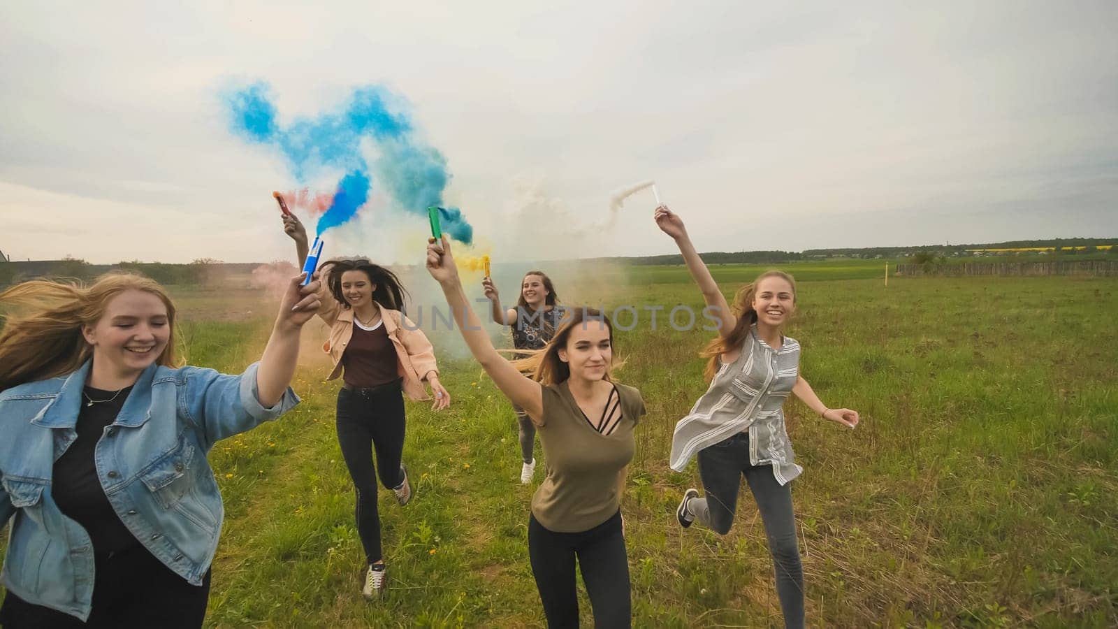 Happy friendly friends are running with toy planes that emit colored smoke