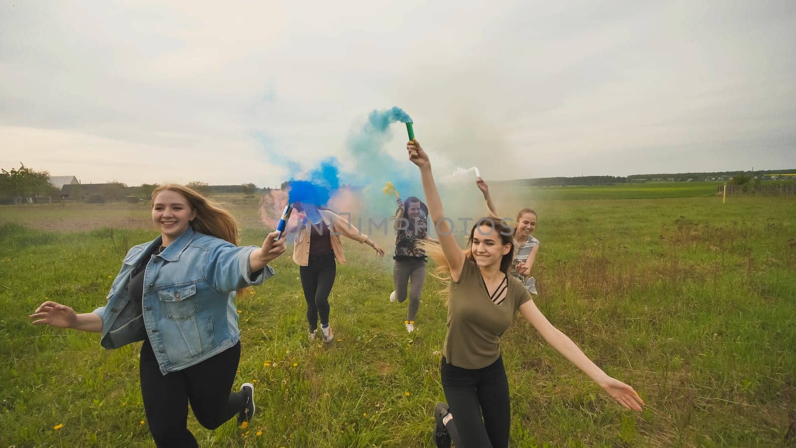 Happy friendly friends are running with toy planes that emit colored smoke