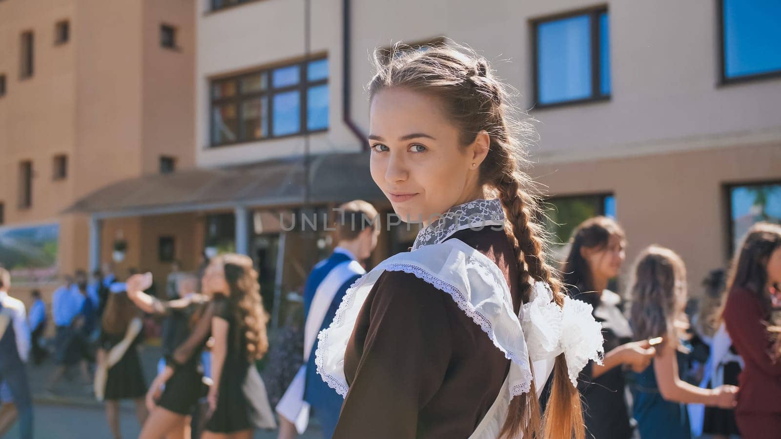 Happy Russian girl graduate with pigtails on the day of graduation