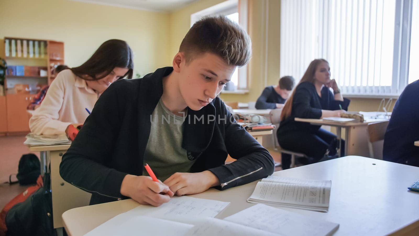Schoolchild in class busy with work. Russian school