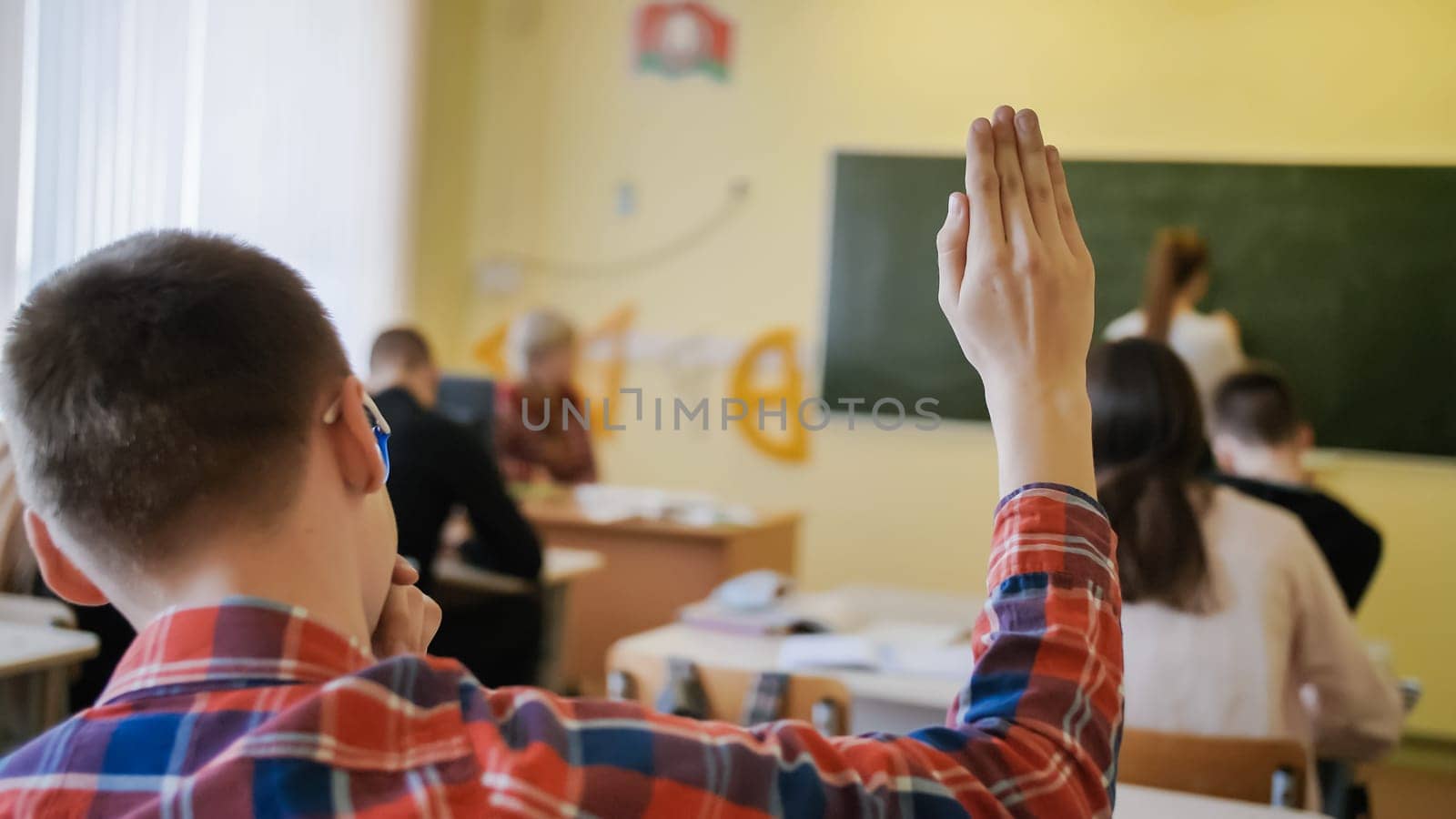 High school student raises his hand during the lesson