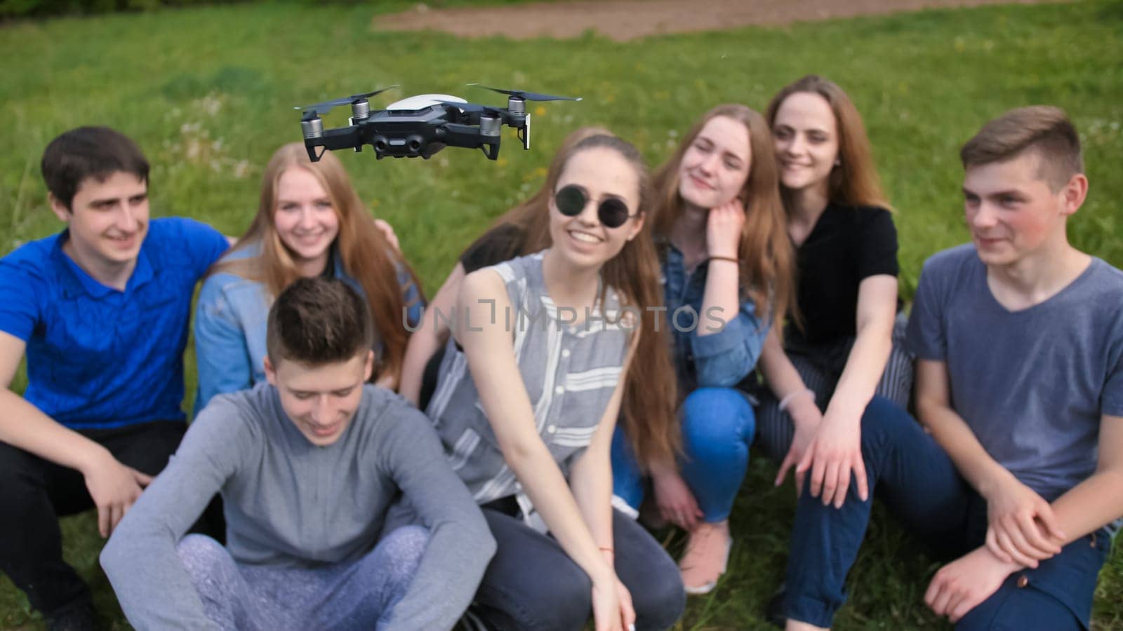 Cheerful friends are watching the flight of the drone