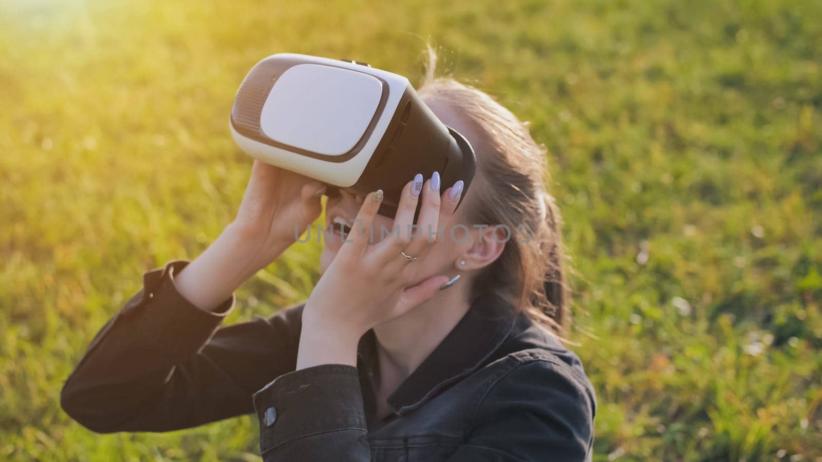 Young girl in virtual glasses in a city park