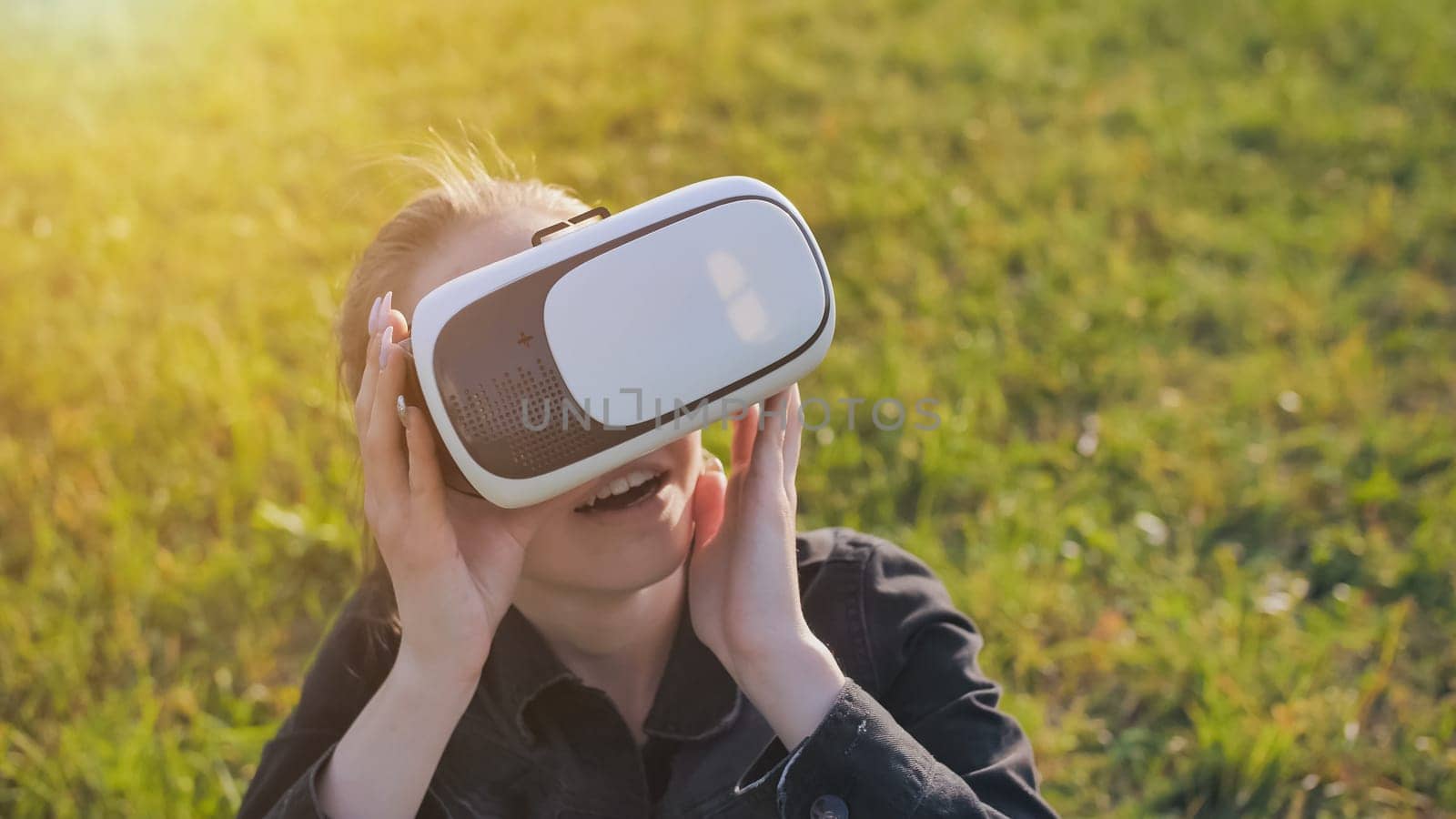 Young girl in virtual glasses in a city park