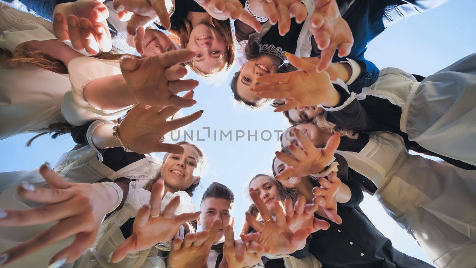 Happy friends connected in a ring together. View from the bottom. The concept of strong friendship