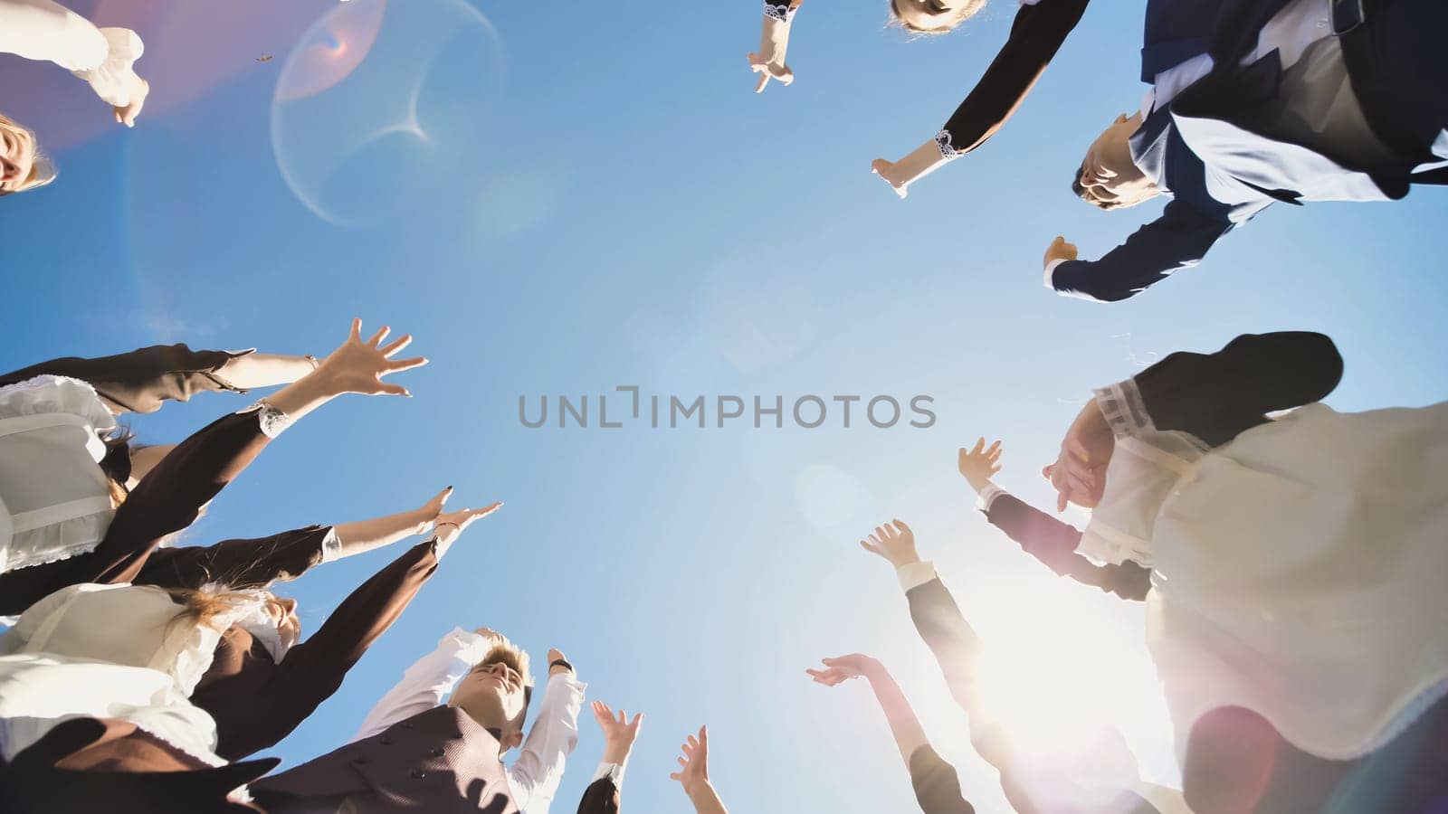 Happy friends graduates join hands together. The concept of a friendly team