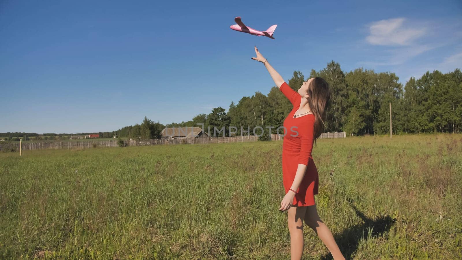 A girl launches a toy paralon airplane into the sky