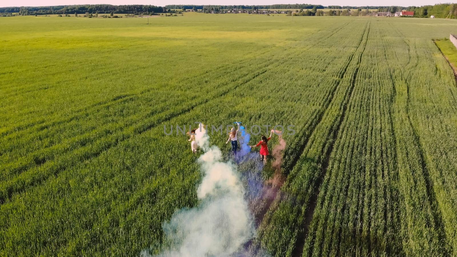 Happy friendly friends run across the field with toy planes that emit colored smoke