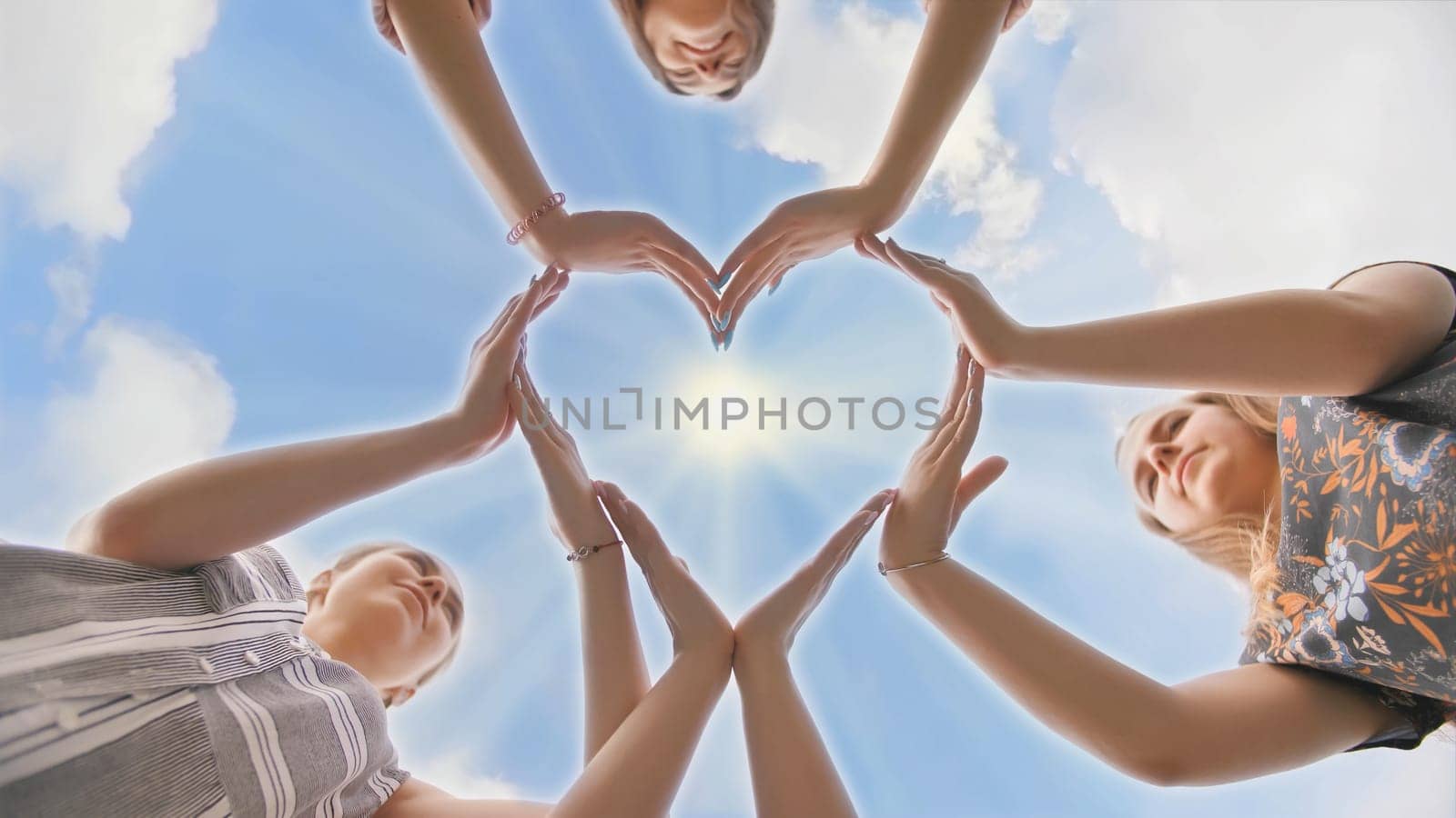 A group of youth makes a heart shape out of their hands