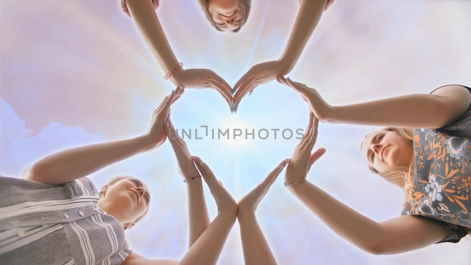 A group of youth makes a heart shape out of their hands