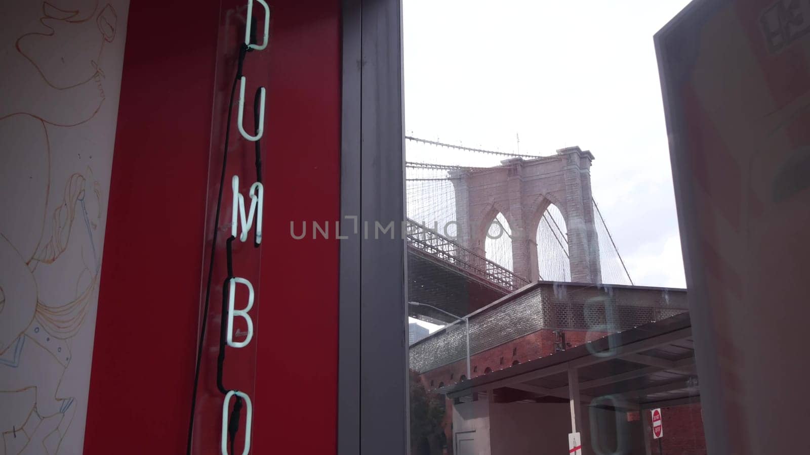 New York City, United States - 30 Aug 2023: Brooklyn Bridge from Dumbo. Red brick wall, old historic tobacco warehouse near Market and Theater. Neon letters vintage sign in cafe window. Travel USA.
