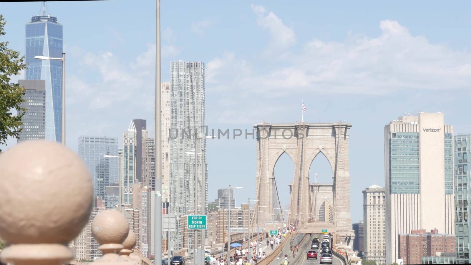 New York City, United States - 3 Sept 2023: Cars on Brooklyn Bridge from Manhattan downtown. Financial district skyline cityscape. Road traffic, people, architecture. World Trade Center skyscraper.