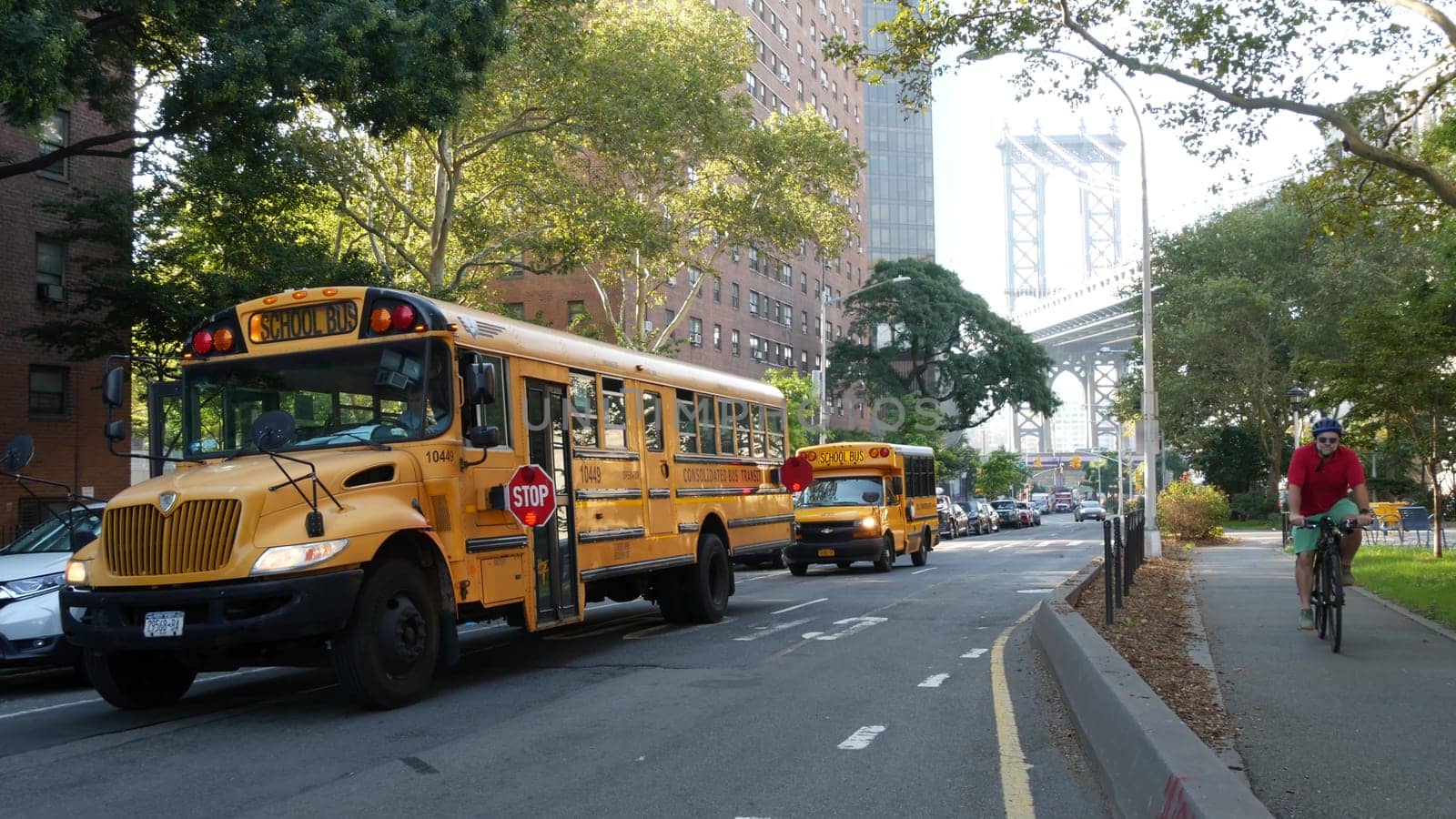 New York City, United States - 7 Sept 2023: Yellow School Bus, Manhattan bridge, schoolbus truck, city street. Children education and USA transportation. American residential district school shuttle.