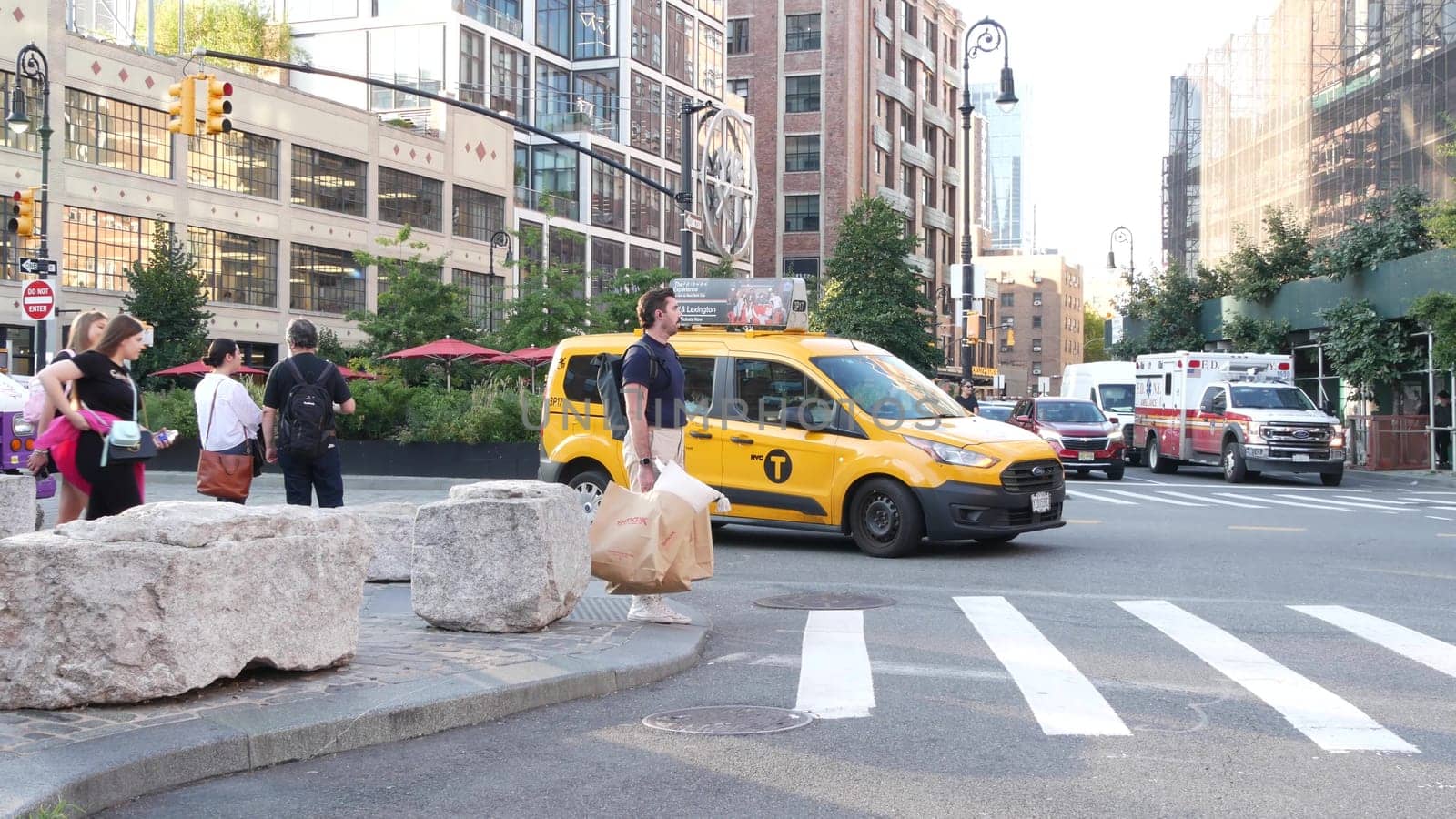 New York City, United States - 2 Sept 2023: Manhattan Midtown street, Chelsea, 9 avenue. Meatpacking district road car traffic, USA. People, yellow taxi cab. FDNY emergency ambulance paramedic truck.