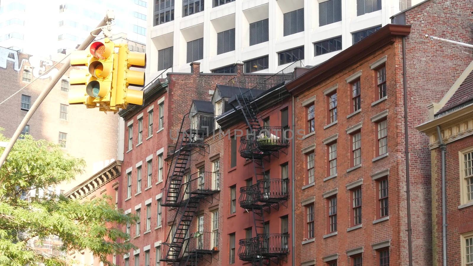 New York City, United States - 31 Aug 2023: Street crossroad, traffic light, transport road intersection. Residential building. Red brick house, fire ladder. Manhattan downtown financial district FiDi