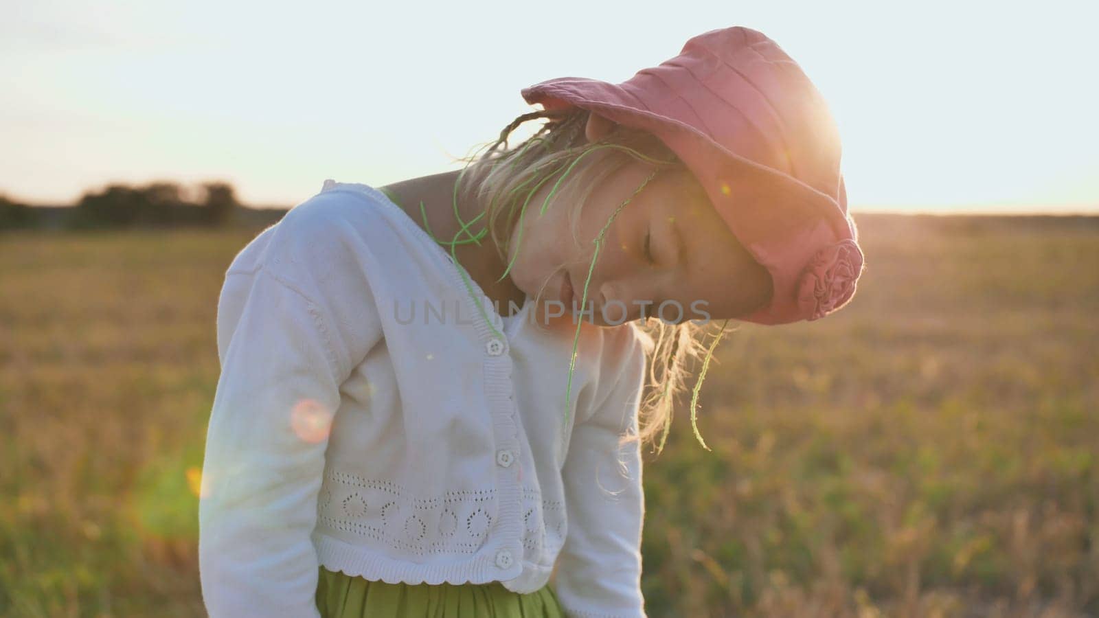 Little girl sleeps standing in the evening at sunset