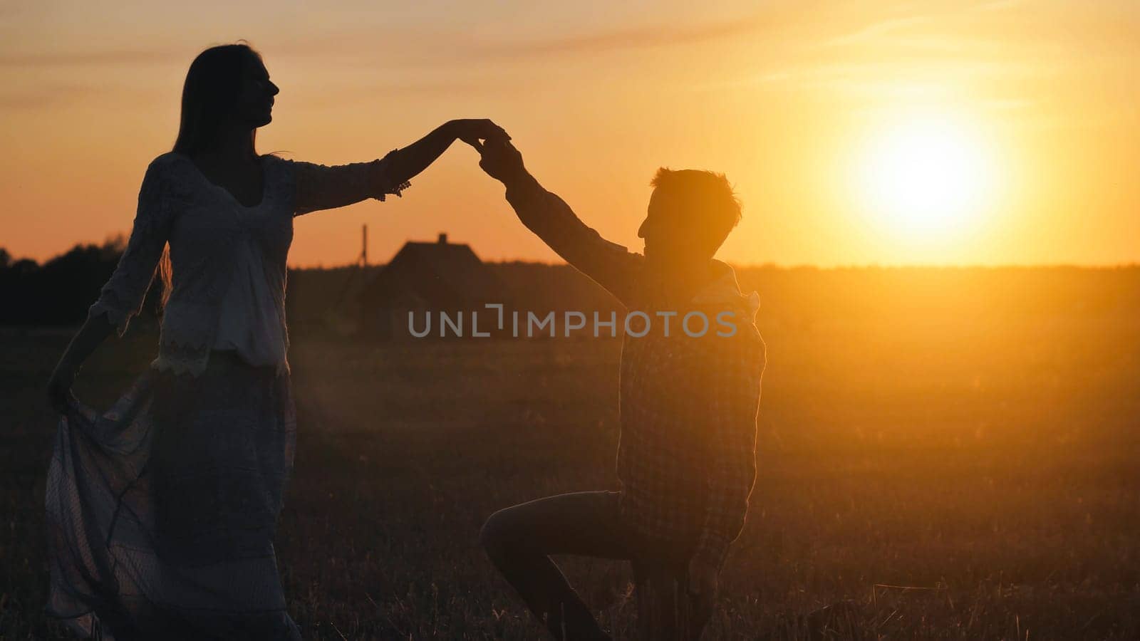 Silhouettes of a dancing couple in love at sunset