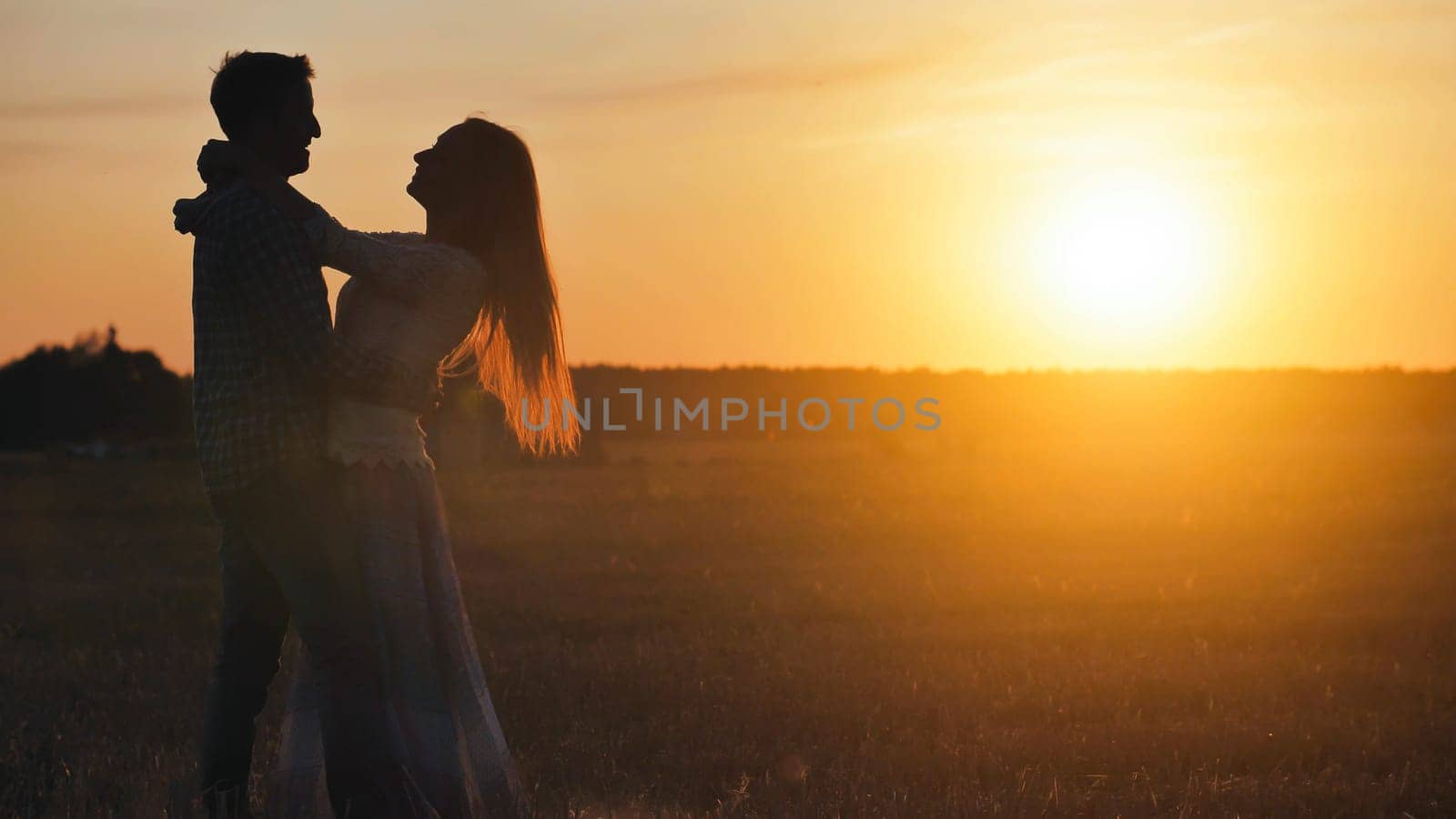 Silhouettes of a dancing couple in love at sunset